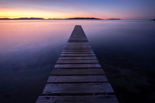 brown wooden dock on body of water during sunset in Hyères France