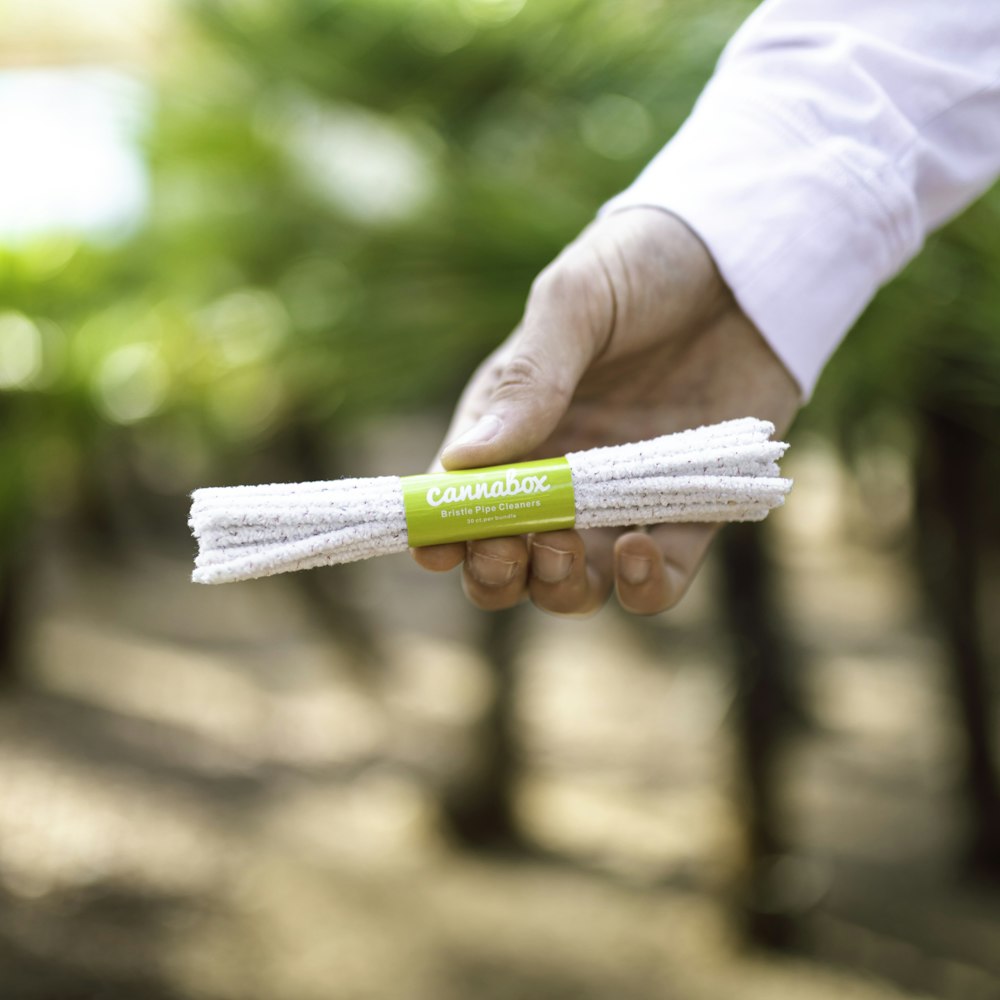 person holding white and yellow soft tube