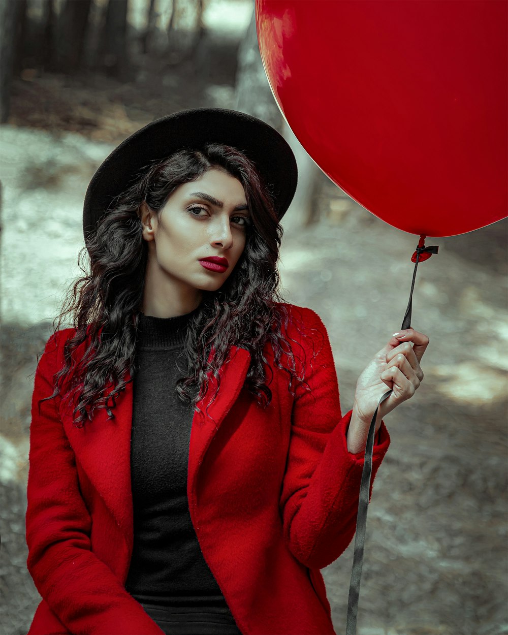 woman in red long sleeve shirt holding red balloon