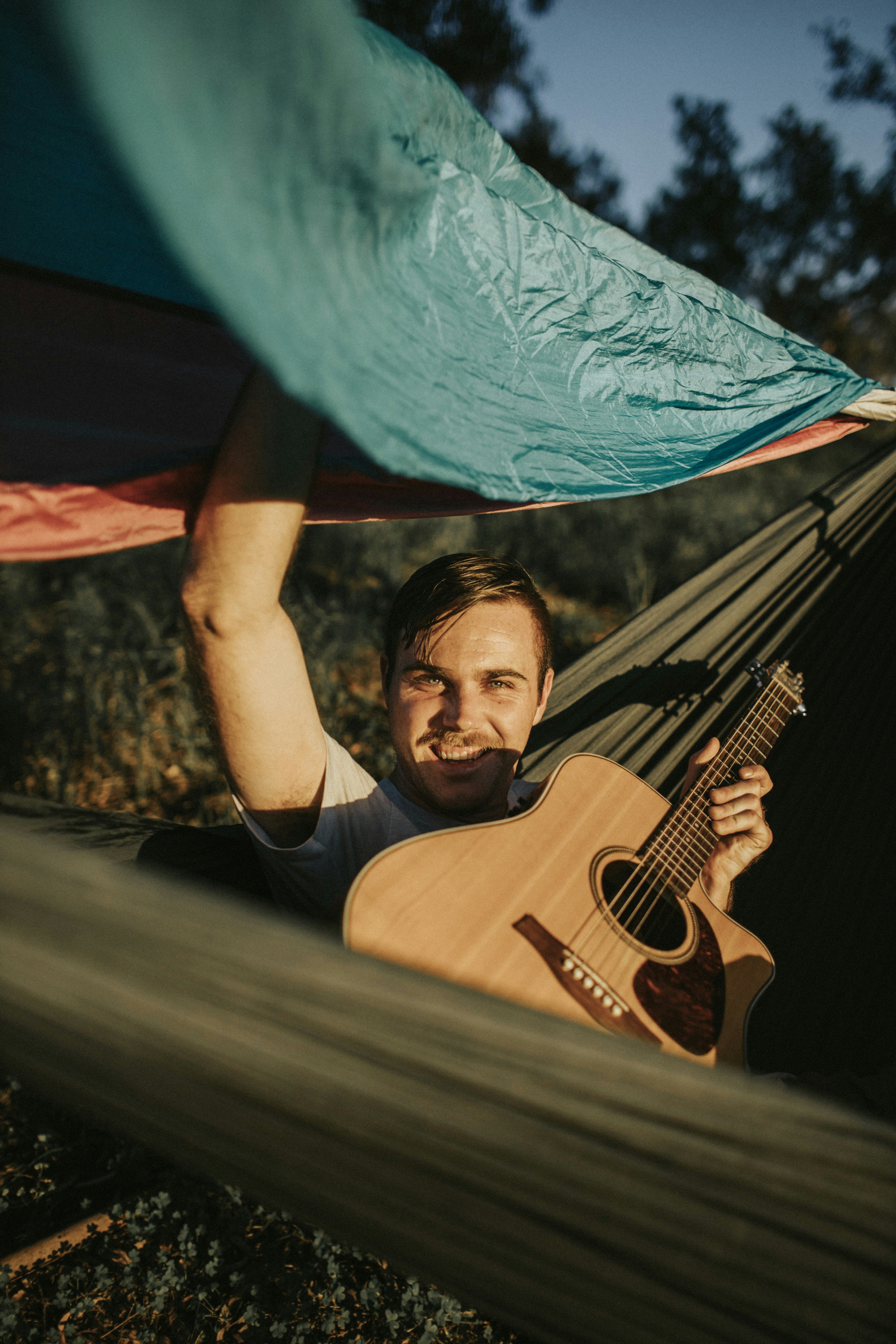 man in black crew neck t-shirt holding blue umbrella