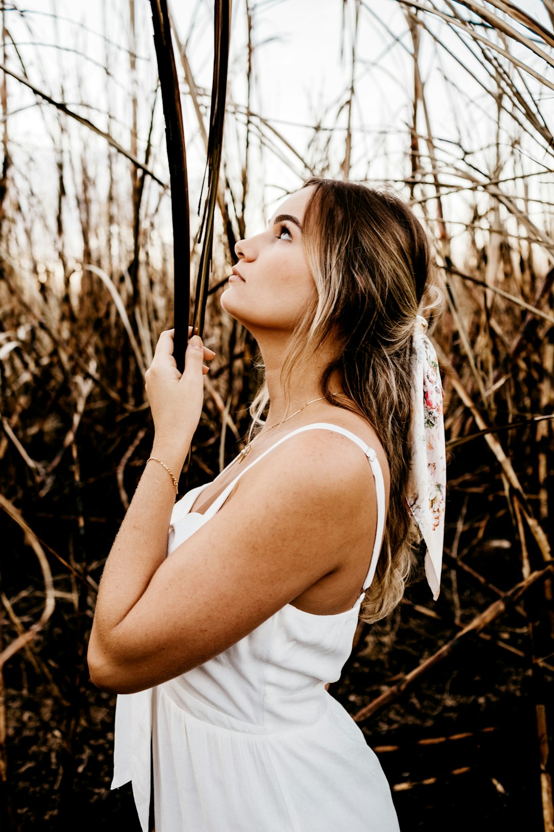 woman in white tank top holding umbrella