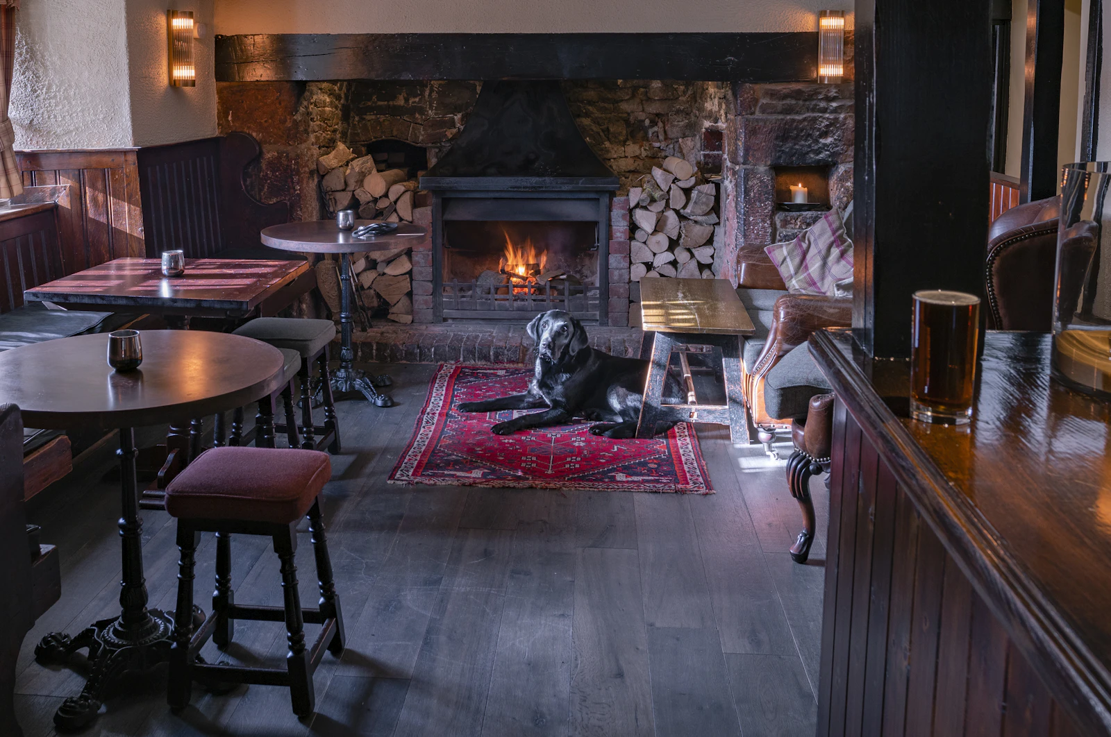 A black labrador lying by the fire in a pub