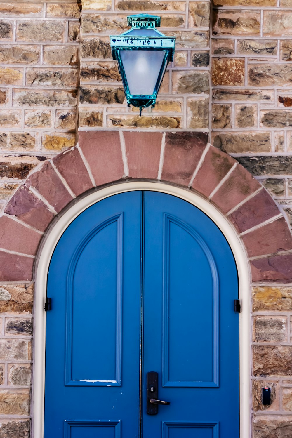 blue wooden door on brown brick wall