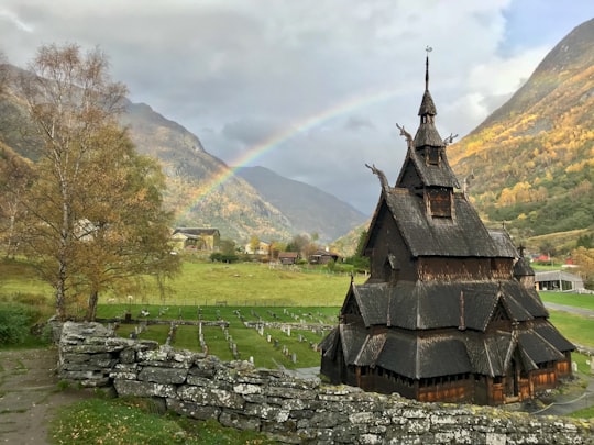 brown and gray concrete house on green grass field near green trees during daytime in Borgund Stave Church Norway