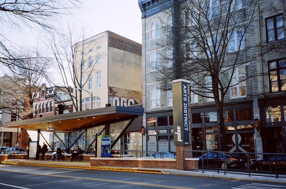 a city street with tall buildings and a bus stop