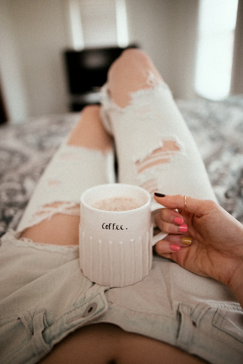 Person mit weißem Keramikbecher mit Kaffee