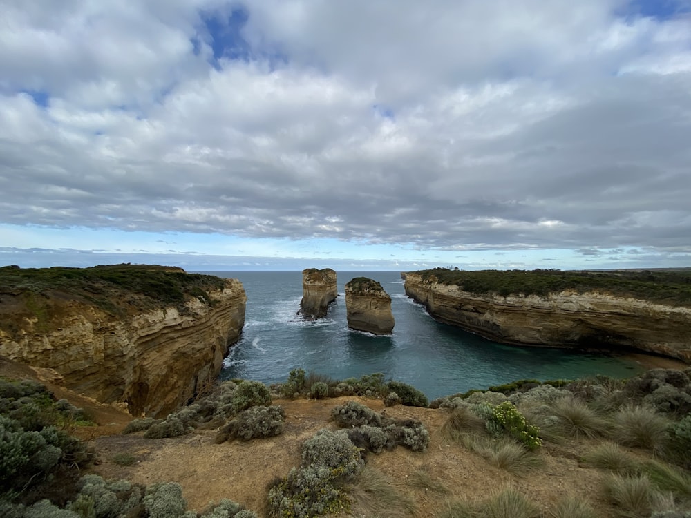 brown rock formation on sea under blue sky during daytime