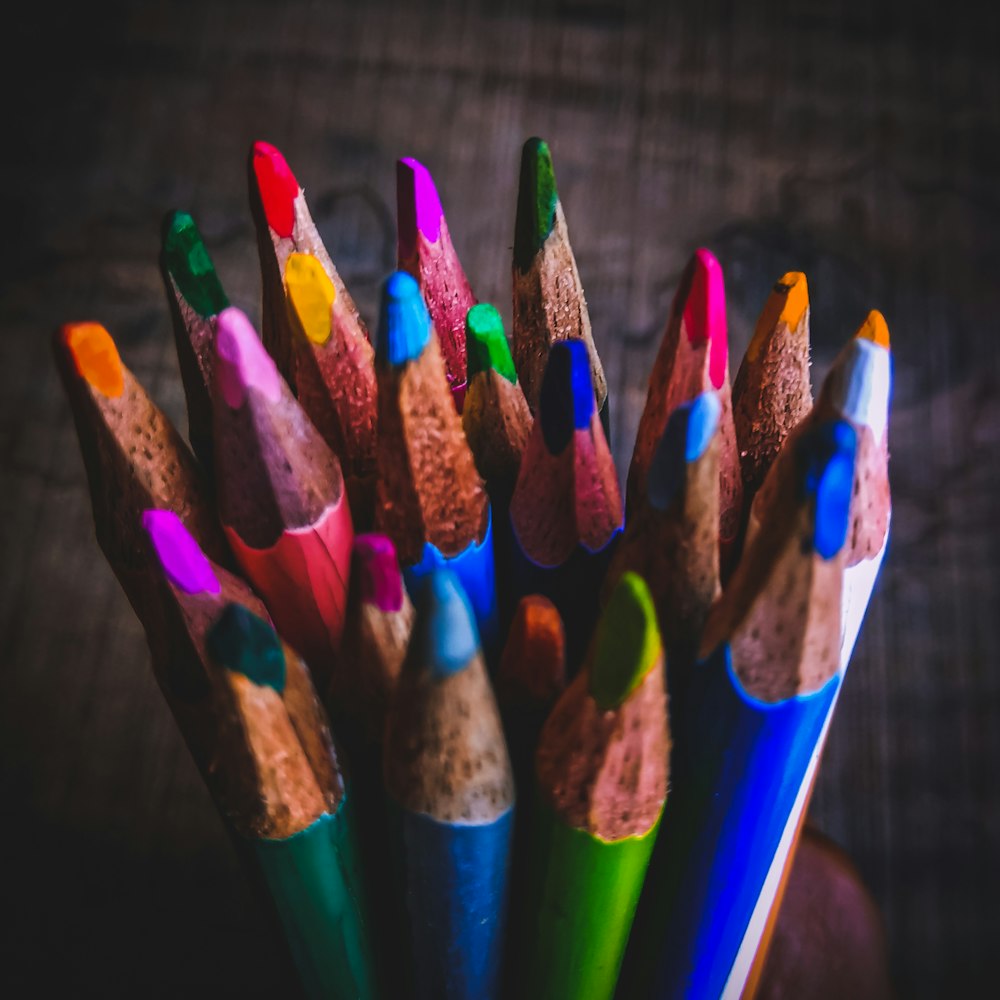 a group of colored pencils sitting in a cup