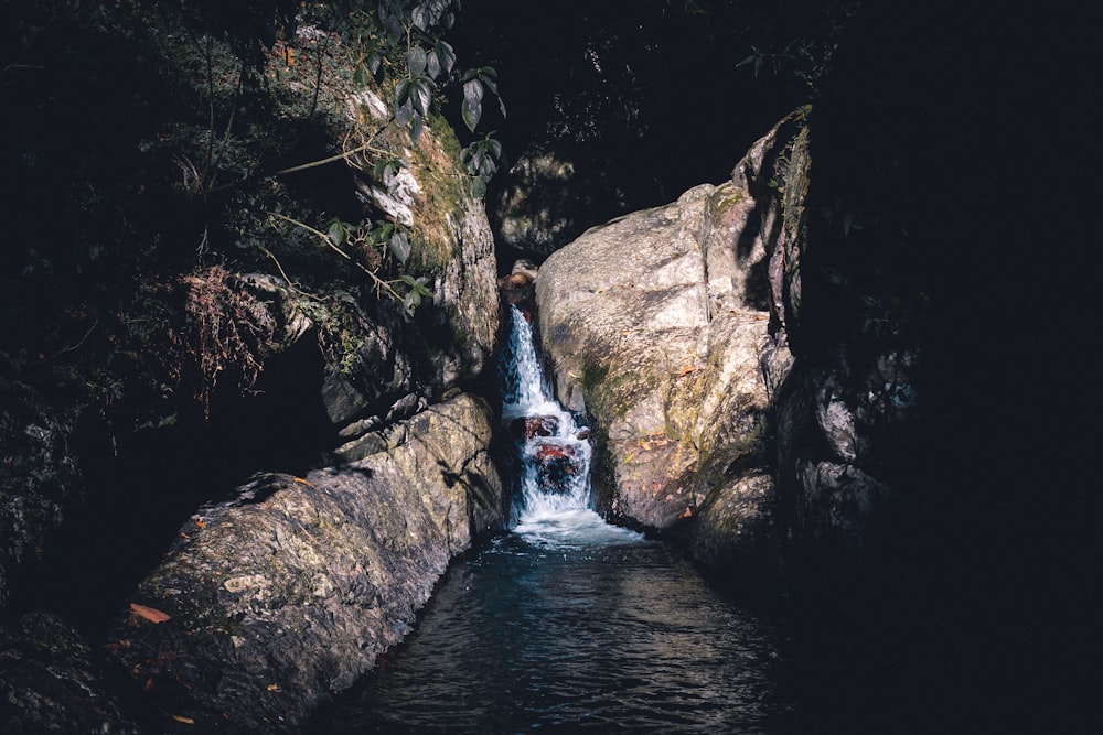 water falls between brown rocks