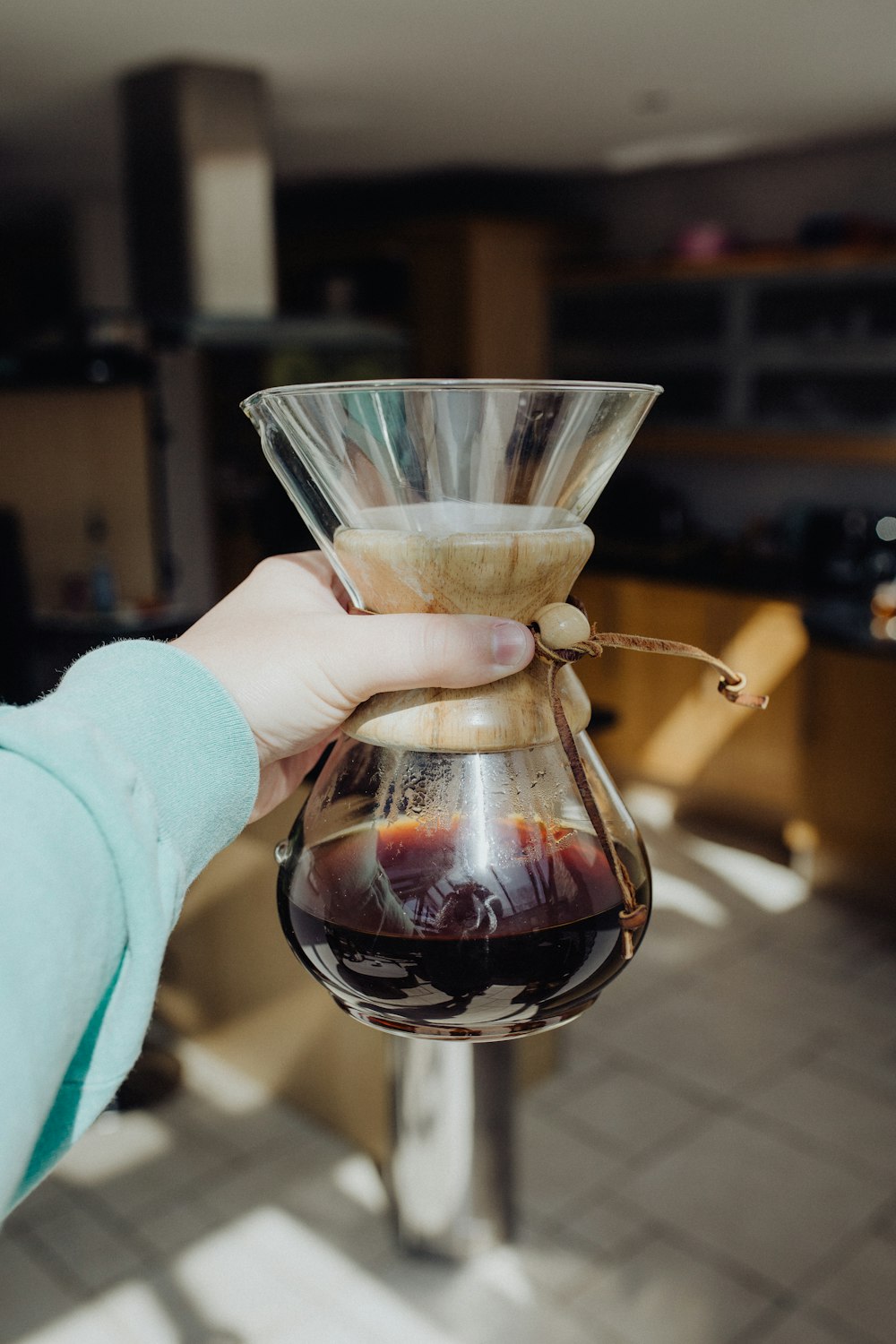 a person holding a wine glass in a kitchen