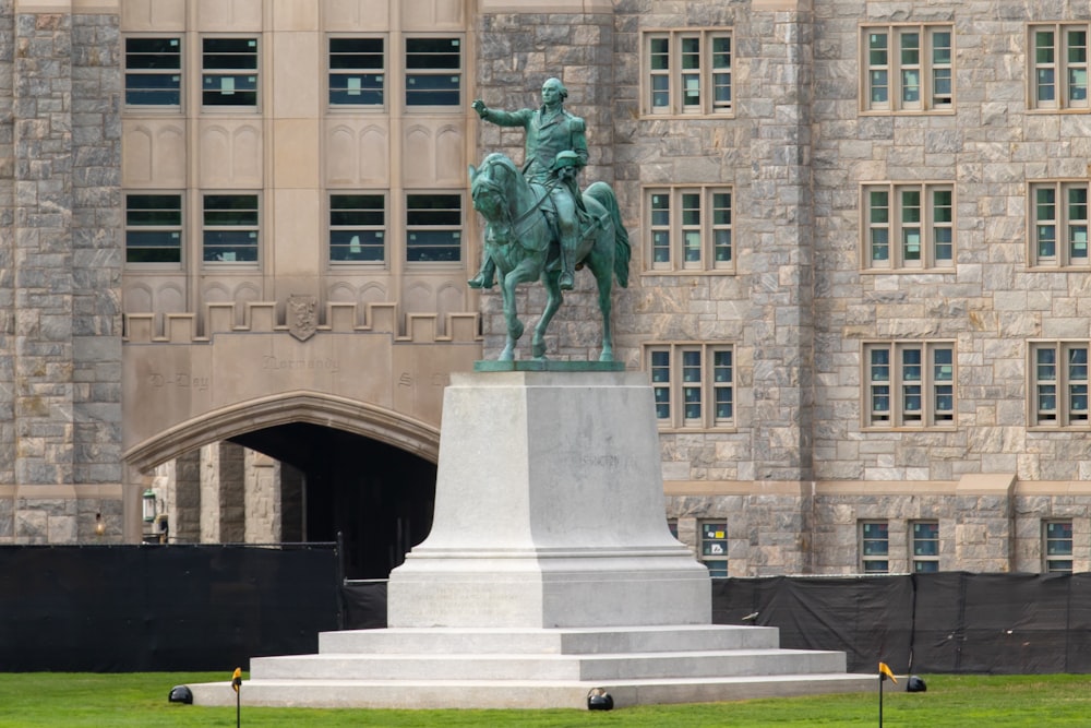 statue of man riding horse near building during daytime