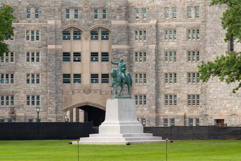 man riding horse statue near brown building during daytime