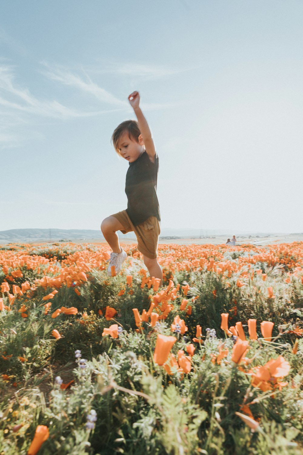 woman in black tank top and black shorts standing on flower field during daytime