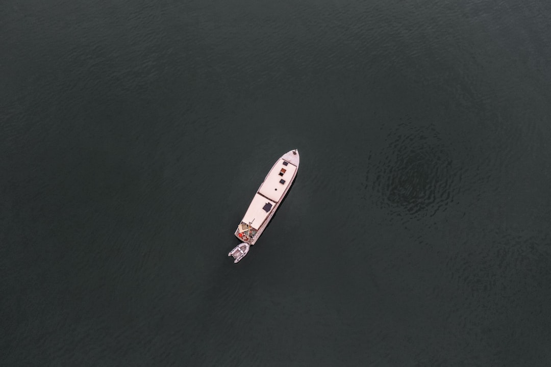 white and red boat on body of water during daytime