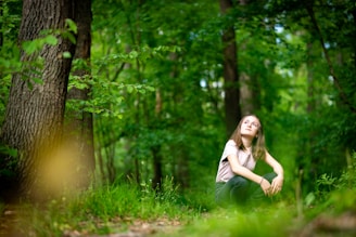 woman in white shirt standing on green grass field during daytime