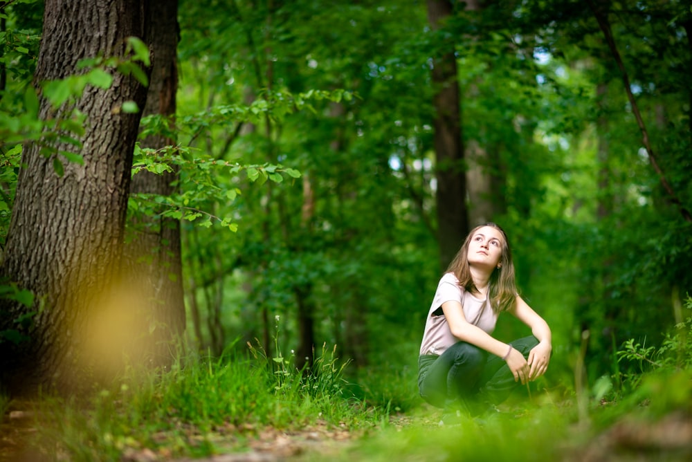 woman in white shirt standing on green grass field during daytime