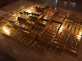 Close-up of gleaming gold bullion bars stacked neatly in a secure vault.