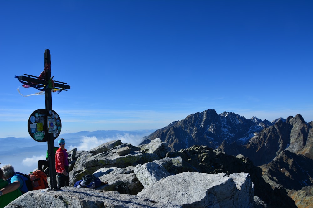 Persona con chaqueta roja de pie en la montaña rocosa durante el día