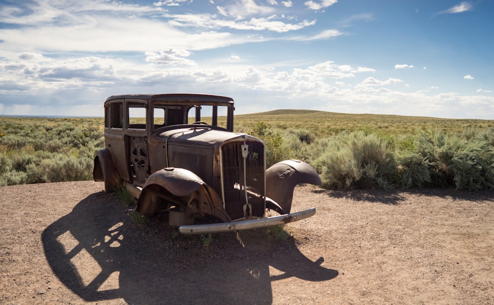 brown vintage car on brown dirt road during daytime