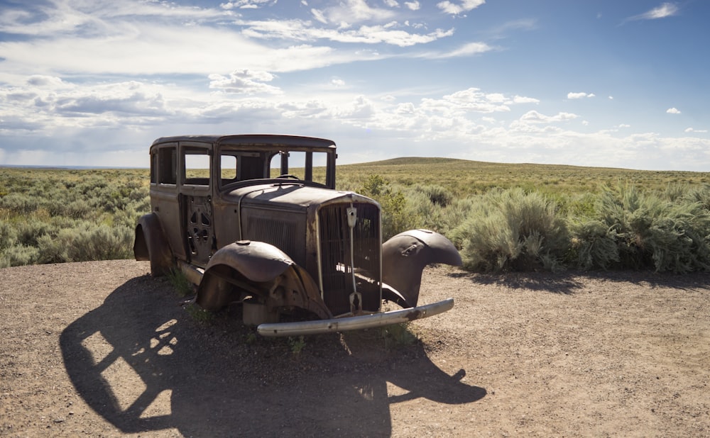 brown vintage car on brown dirt road during daytime