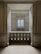 An elegant space with marble walls and a decorative balustrade. A window with a grid design is centered in the background, allowing soft light to enter the room, creating a calm and serene atmosphere.