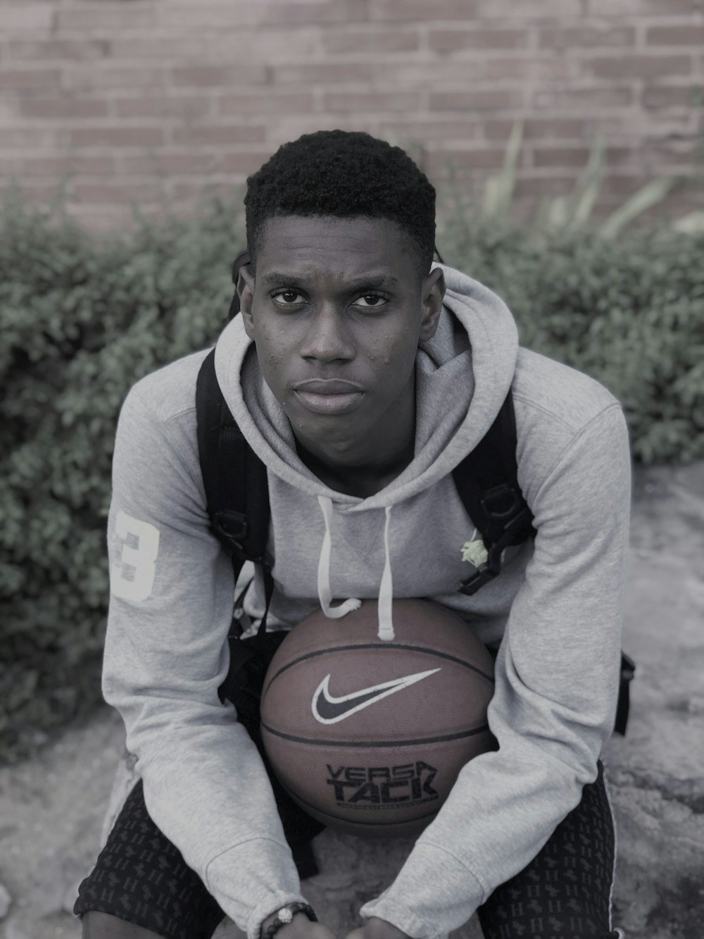 man in purple and white hoodie holding basketball