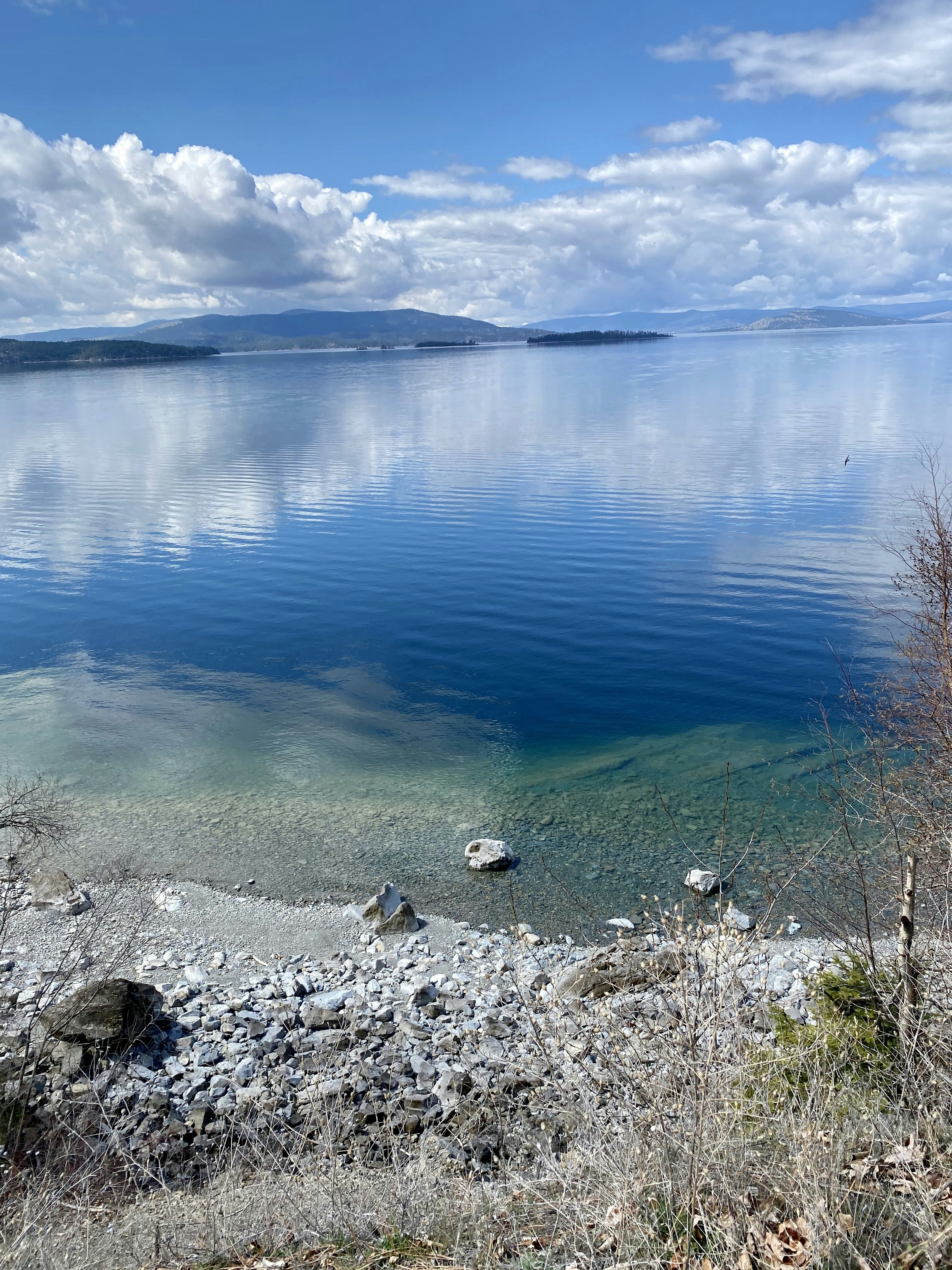blue calm water near gray rocks during daytime