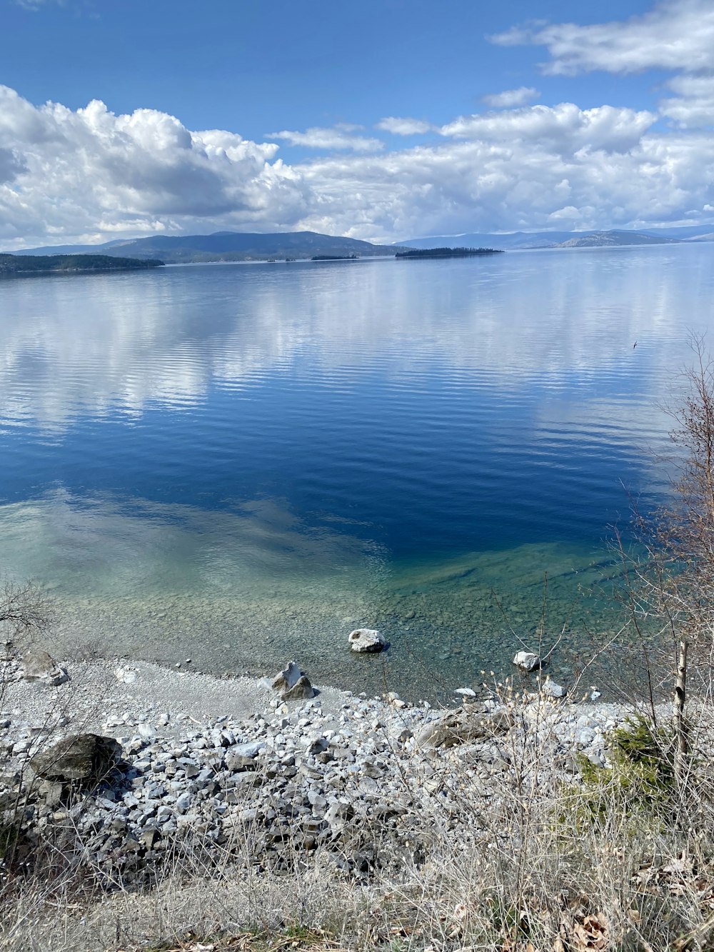 blue calm water near gray rocks during daytime