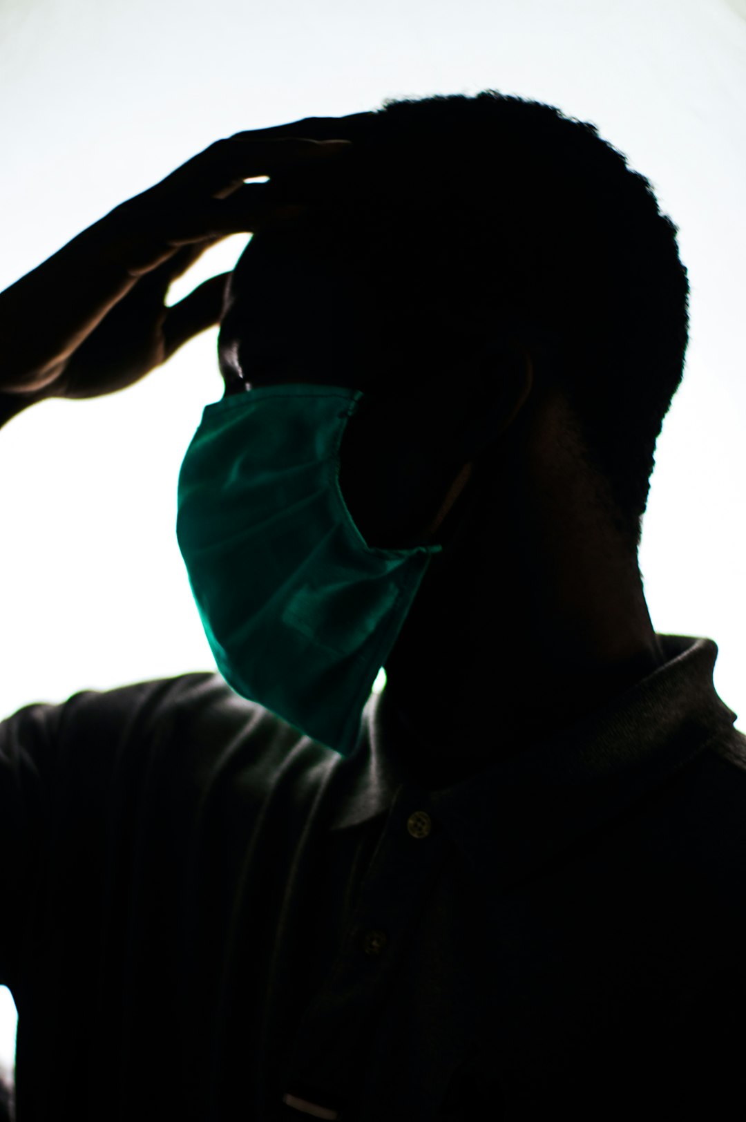 man in black jacket covering his face