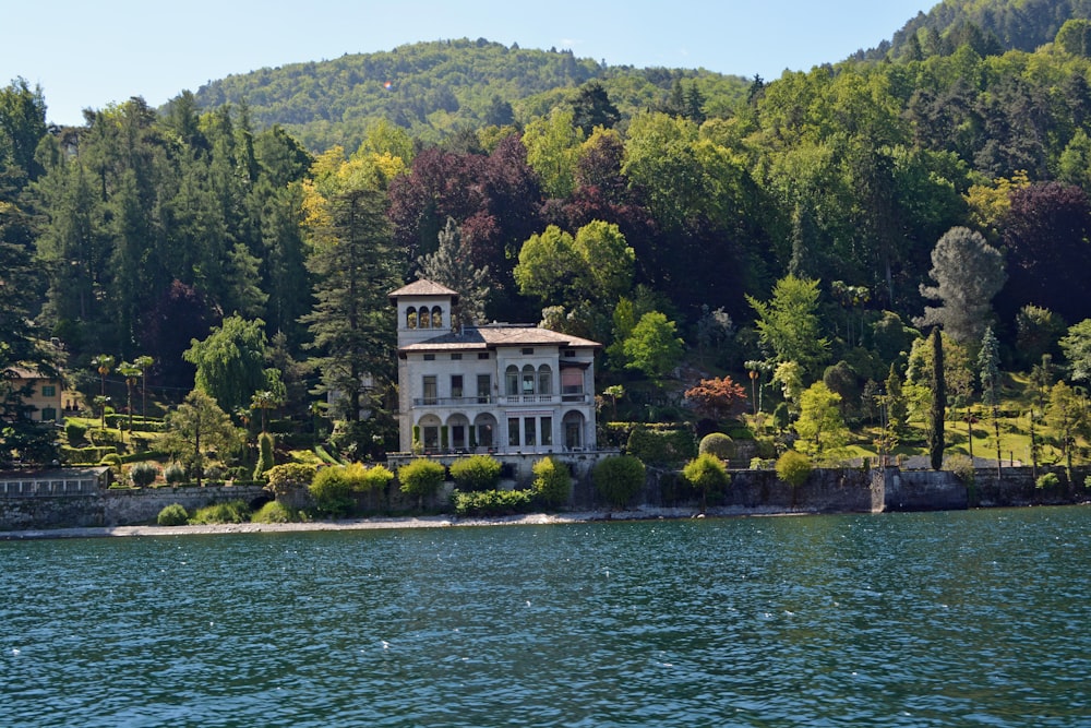 white concrete building near green trees and body of water during daytime