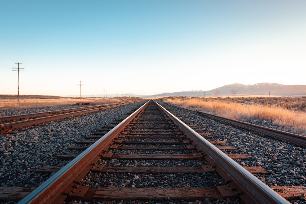 Carril de tren marrón bajo el cielo azul durante el día