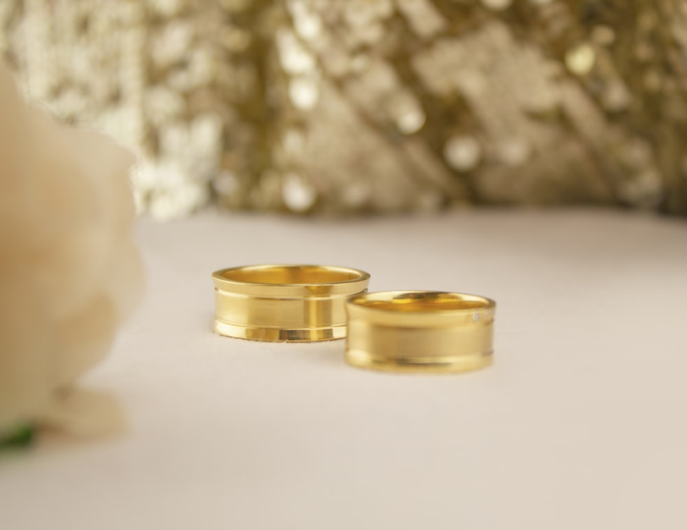 gold wedding band on white surface