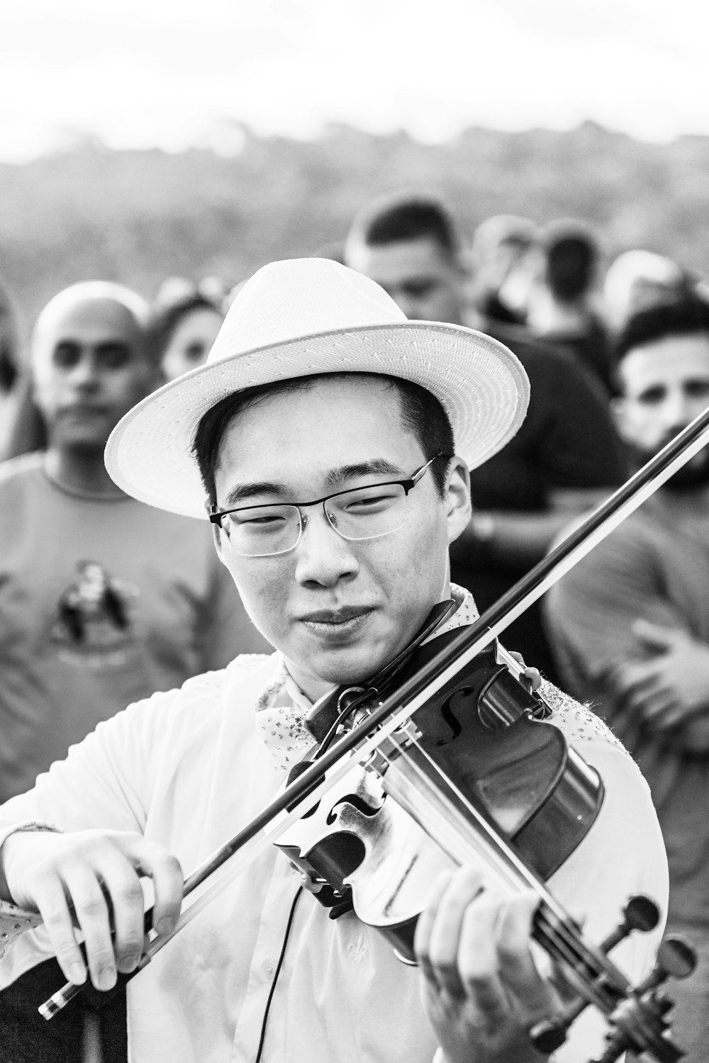 man playing violin in grayscale photography