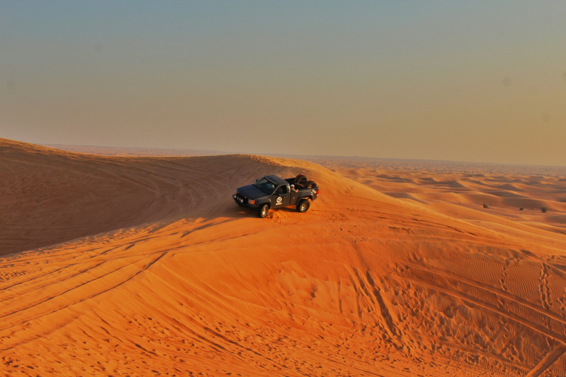 Toyota Hilux 4x4 driving over sand dunes