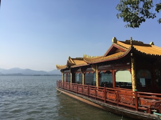 brown wooden house on body of water during daytime
