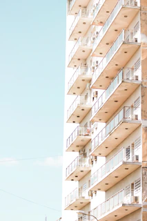 A smiling family standing next to their home’s new glass balcony railing on a clear day