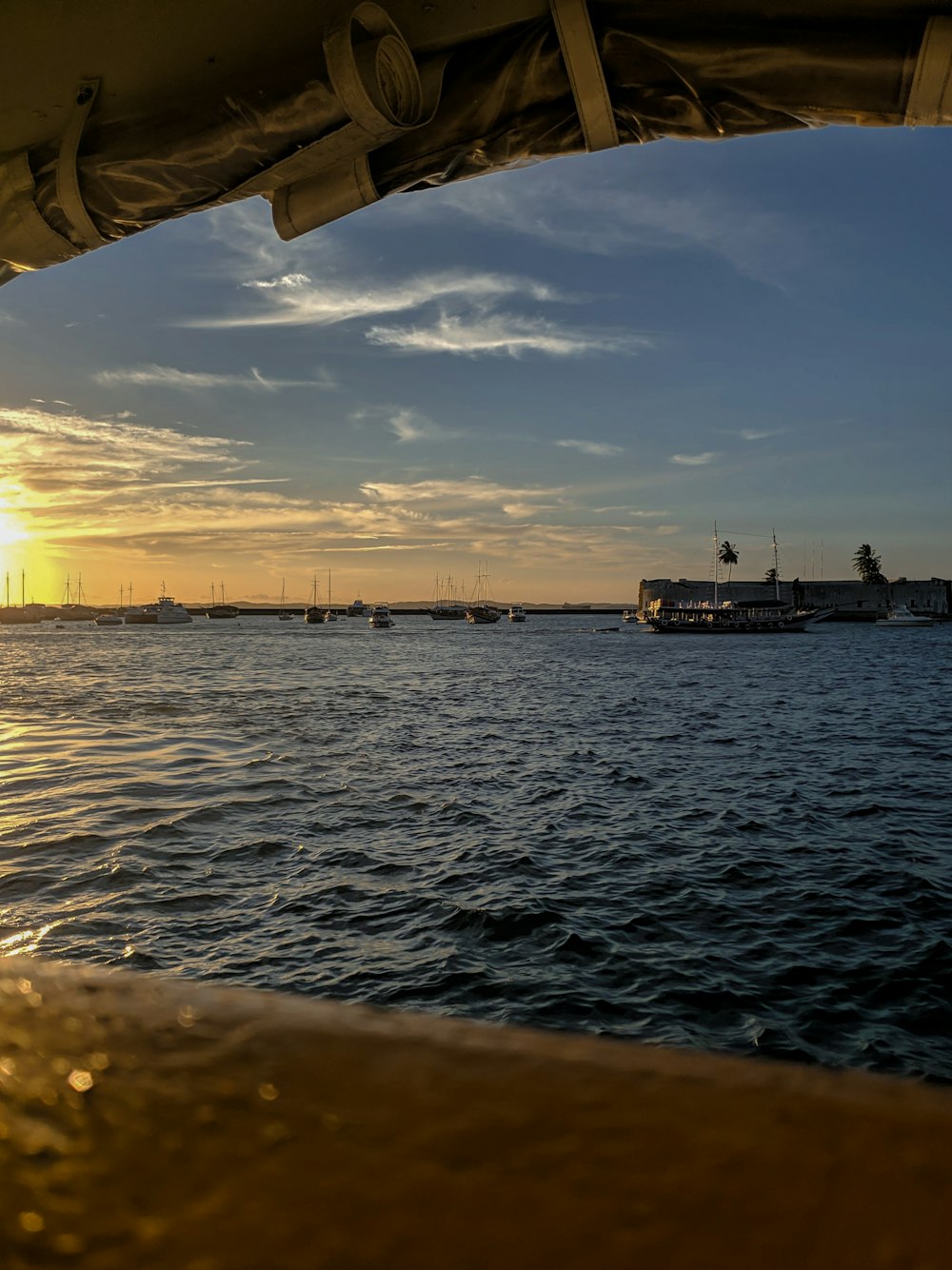 silhouette of boat on sea during sunset