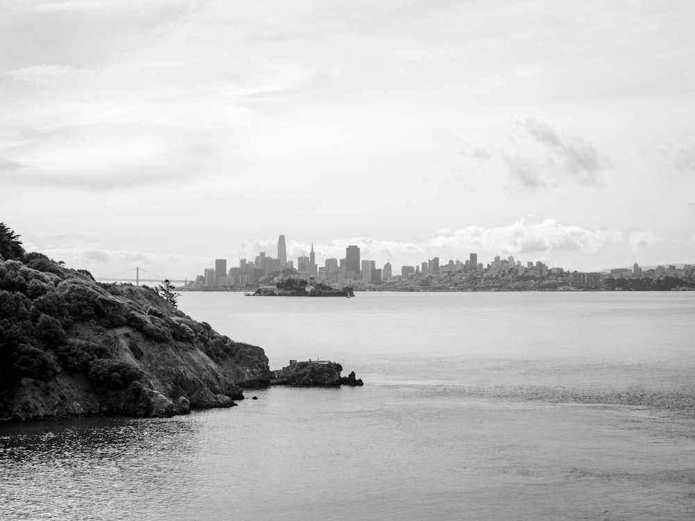 grayscale photo of body of water near city buildings