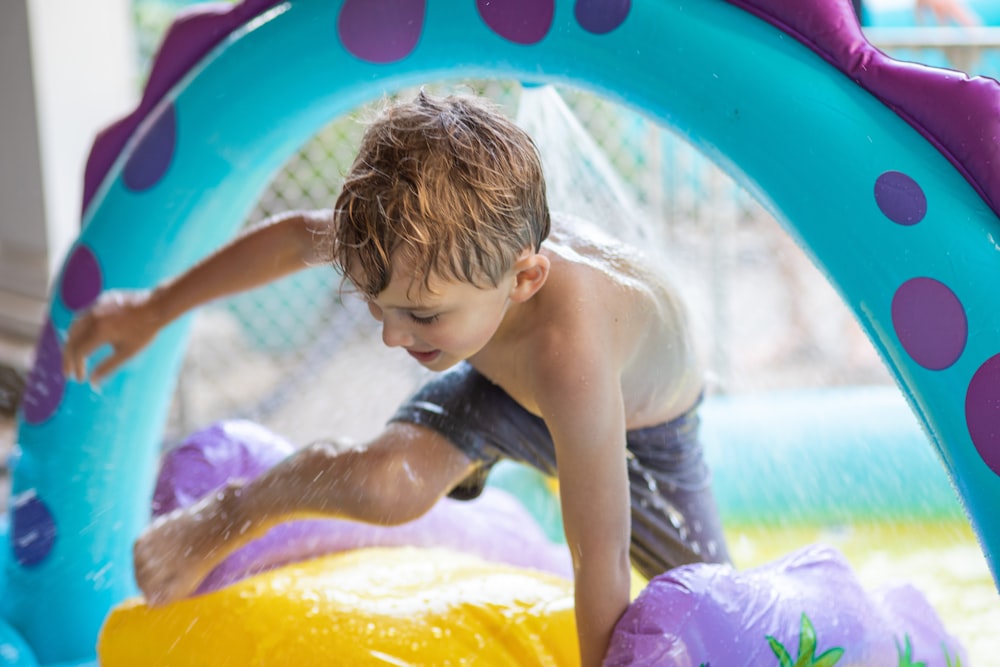 girl in white tank top sitting on inflatable pool