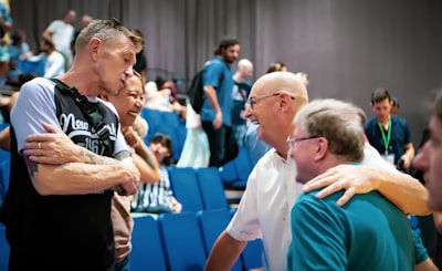 woman in white shirt standing beside man in green shirt friendly teams background