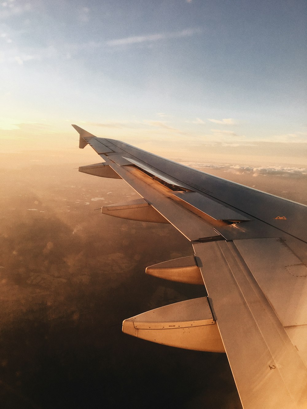 airplane wing over white clouds during daytime