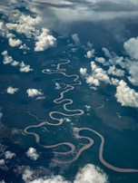 An aerial shot of a winding river cutting through a lush green landscape.