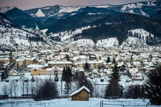 brown and white houses near snow covered mountain during daytime in Vatra Dornei Romania