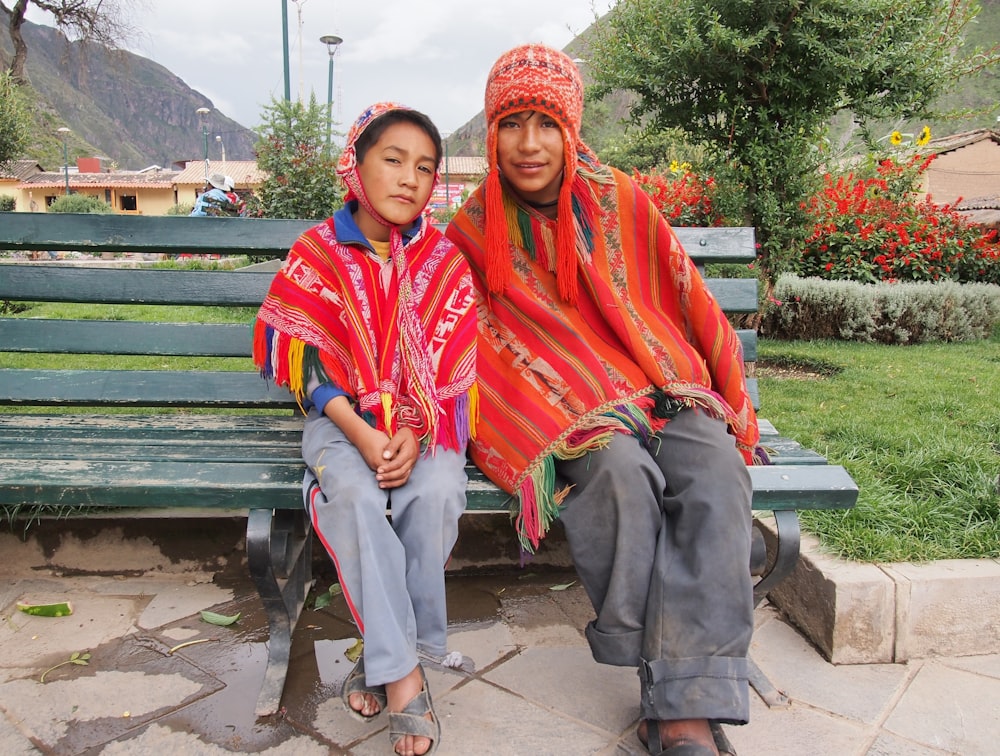 man in red and blue scarf sitting on green wooden bench