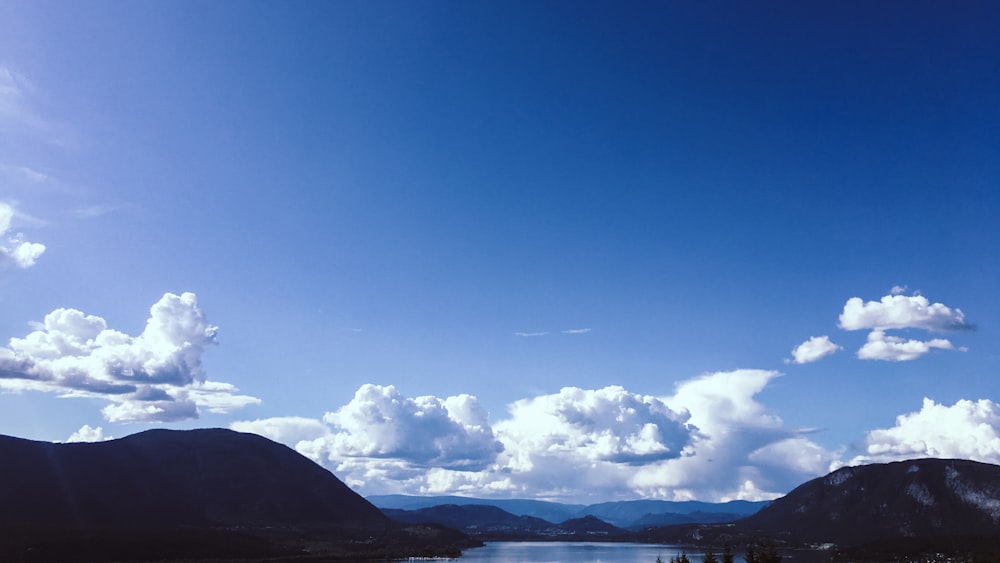 white clouds over mountains during daytime