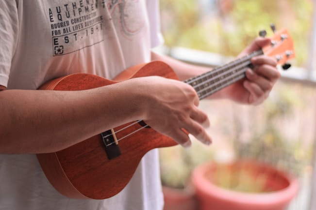 person playing brown acoustic guitar