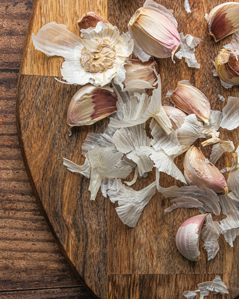 white and brown garlic on brown wooden round table