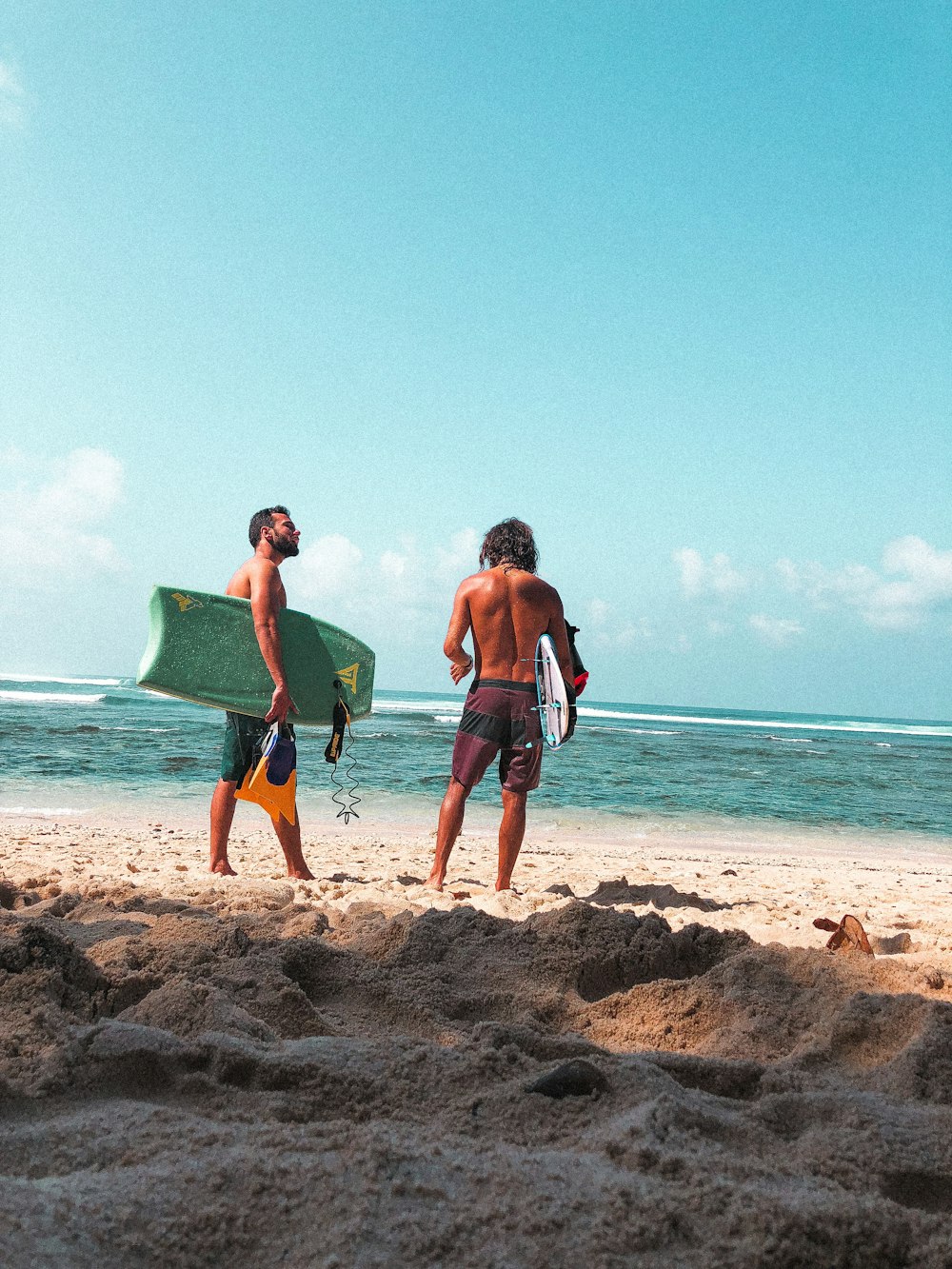 2 hombres y 2 mujeres corriendo en la playa durante el día