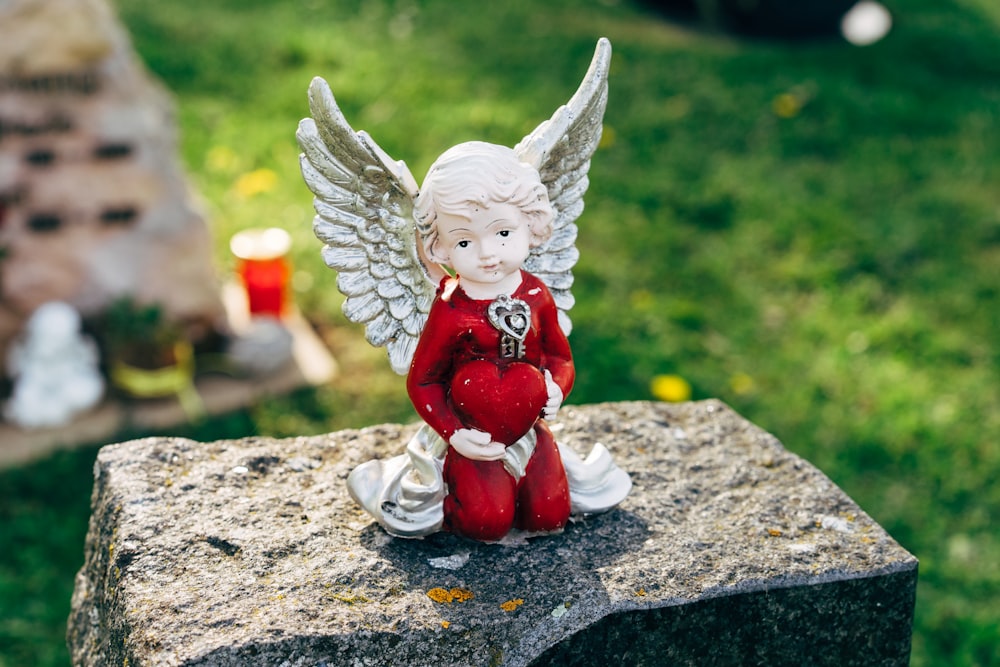 white angel figurine on gray concrete surface