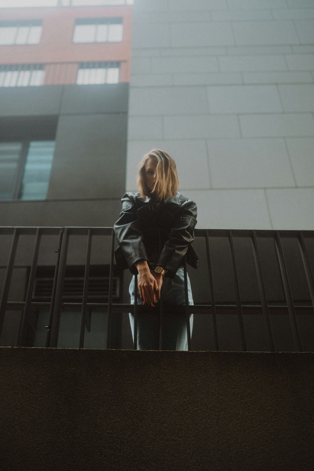 woman in black leather jacket standing on black staircase